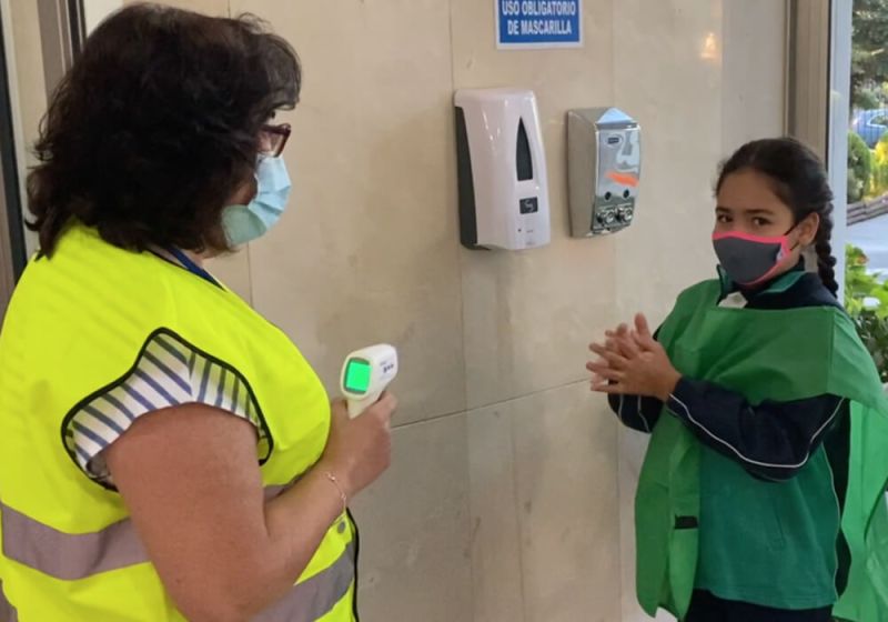 Mujer tomando temperatura a niña
